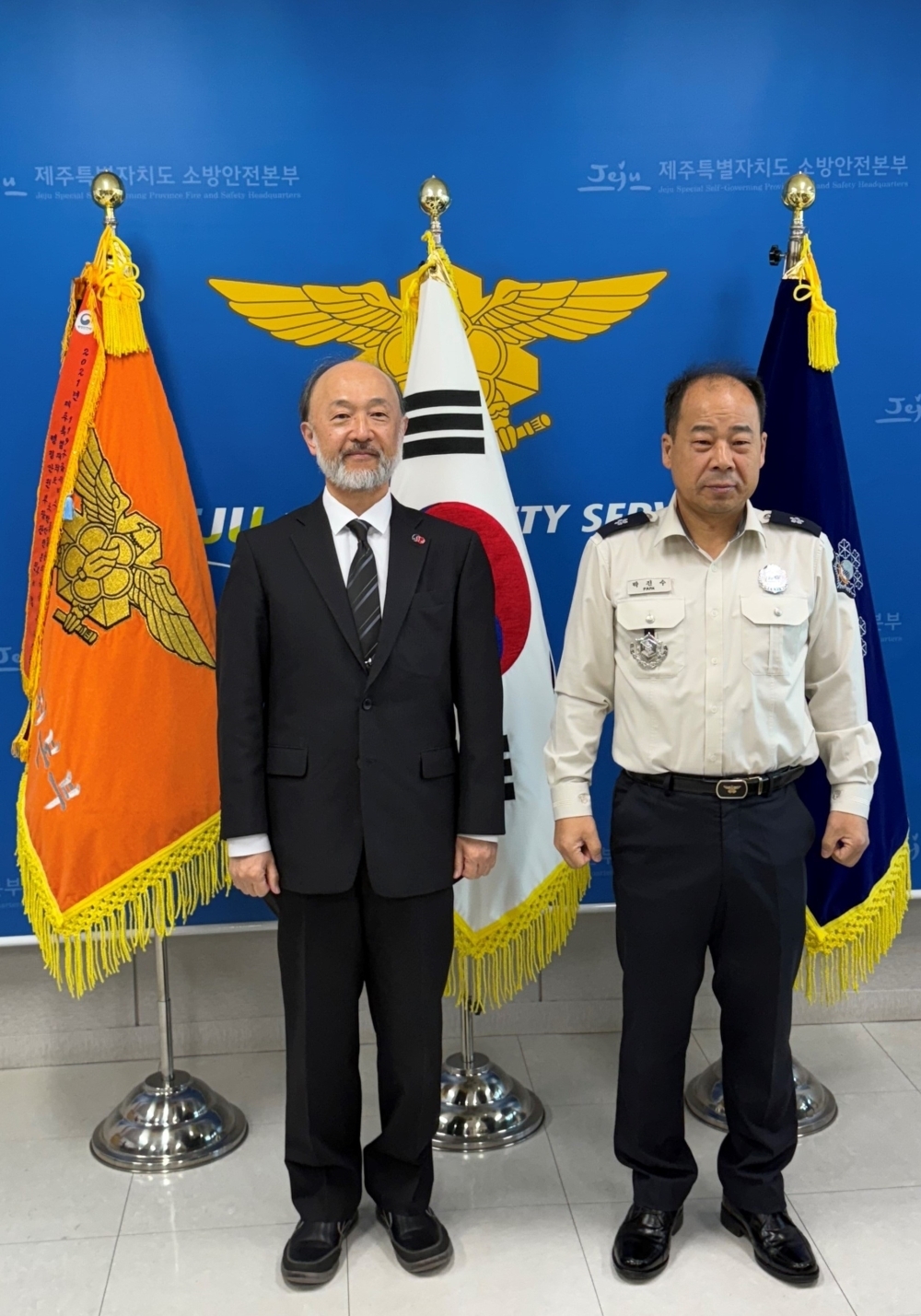 パク・ジンス本部長と記念撮影を行う池田総領事